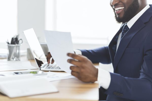 Cropped photo of happy african entrepreneur looking at documents